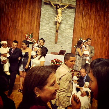 Families mingle and pose for photos after baptising their young children in the church of La Primavera, a wealthy neighbourhood of Cumbaya.