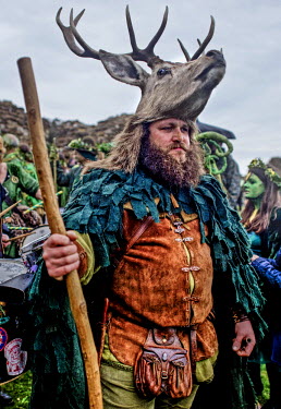 A man wearing a dear head hat at a Jack in the Green festival. The festival is part of a recent revival of an older custom where people would wear frameworks covering much of their bodies which were d...
