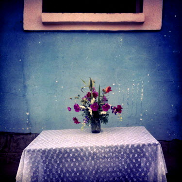 A bouquet of flowers sits on a table outside a house in Rumihuaico.