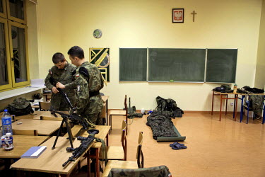 Mateusz, 17, left, a young member of Strzelec (The Shooter), a paramilitary association, examines a replica rifle during a training weekend. Several paramilitary groups from the region joined together...