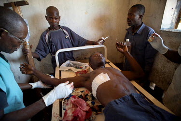Doctors operate on Jean De Dieu Domba, 24, at the health post in Dula, hours after Jean was shot over the nearby border in Central African Republic. Tens of thousands of refugees have recently poured...
