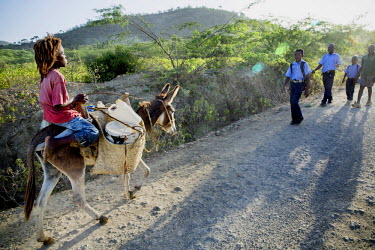 A boy rides his donkey back to the family home after collecting containers of water from a nearby standpipe.
