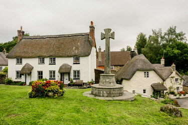 A Celtic Cross and a thatched cottage in the village of Lustleigh which is nestled in the Wrey Valley, within the boundries of Dartmoor National Park.