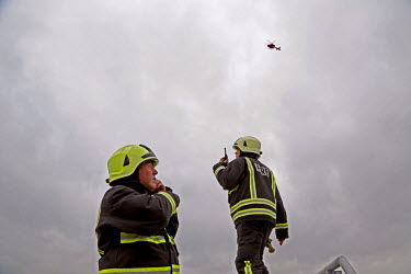 Fire crew prepare for a landing by the helicopter from the air ambulance service. London's Air Ambulance, also known as London HEMS (Helicopter Emergency Medical Service), is a British registered char...