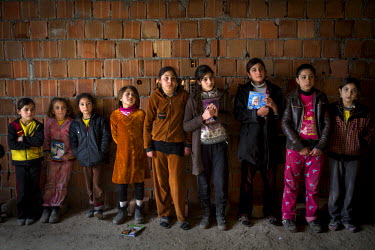 Children from IDP families gather for an informal English class in a room in the unfinished building where they are living. The building is part of a development called Dabin City and its huge tower b...