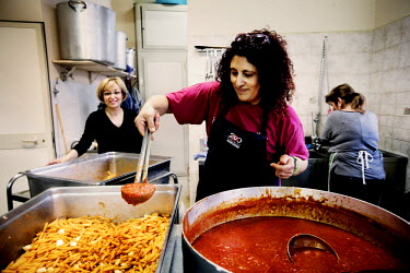 Volunteers from the Catholic charity Caritas cook huge vats of pasta to make food parcels to distribute to the large numbers of migrants who gather at the city's train station.
