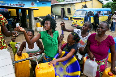 Women queue up to buy water from a community standpipe.