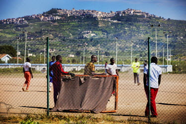 Migrants living at the Mineo centre for asylum seekers play a game of football. Established in 2011 in an old residential compound originally built for the families of US military personnel, it now of...