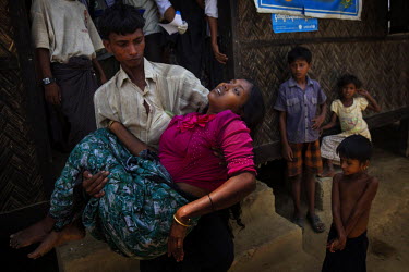 20 year old Rohingya woman Namkin, who suffered a miscarriage two days before when two months pregnant, is carried from a consultation with a visiting doctor from a Ministry of Health 'Mobile Health T...
