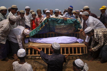The body of Rohingya IDP Nur Hussein, 28, who died the evening before after suffering what appeared to be a severe asthma attack or a respiratory condition, is carried in a coffin to a burial site nea...