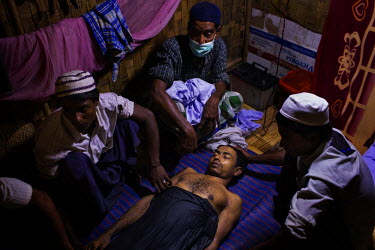 The body of Rohingya IDP Nur Hussein, 28, who died the evening before after suffering what appeared to be a severe asthma attack or a respiratory condition, is prepared for burial in his one room shac...
