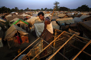 A man rebuilds the roof of his sister in law's shack ahead of the Monsoon rains in the Thae Chaung IDP camp in the Rohingya segregated area north of Sittwe.  The Rohingya are a Muslim people who have...