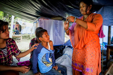 Nurse Kumari Usakiran, 26, gives a tetanus vaccine injection to 10 year old Parlad at a makeshift health post in Suarpani-4 village where 42 people were killed and 22 injured, while barely 10 of 1000...