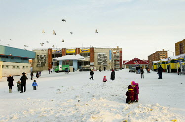 People mill around a square in front of a shopping centre in Norilsk on a snowy day.    The city of Norilsk, in the far north of Russia's Krasnoyarsk region, was founded in the 1920s and today has a p...