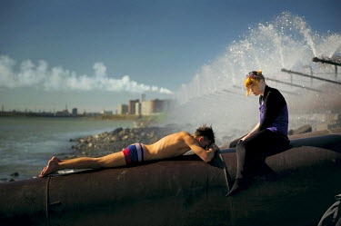 A young man and woman sit on a large industrial pipe alongside an artificial lake in Norilsk during the summer. For many young people who grow up in the city their main aim in life is to leave. Most w...