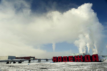 A large red sign which reads 'Nadezhda' ('Hope') marks the entrance to one of the smelters belonging to Norilsk Nickel.  The complex consists of three plants - the nickel plant, the copper plant and '...