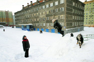 Children play in the snow next to a drab Soviet Era housing estate in Norilsk. The city is covered in snow for around 8 to 9 months a year. Each year around 10 tonnes of snow fall on the city for each...