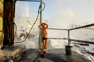 A child takes a shower after enjoying a dip in an icy lake as part of the so-called 'Walrus' club. A popular past time is to take a dip in holes cut into the ice and then retire to a 'banya' (or sauna...