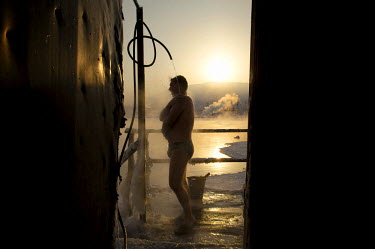 A man takes a shower after enjoying a dip in an icy lake as part of the so-called 'Walrus' club. A popular past time is to take a dip in holes cut into the ice and then retire to a 'banya' (or sauna)...