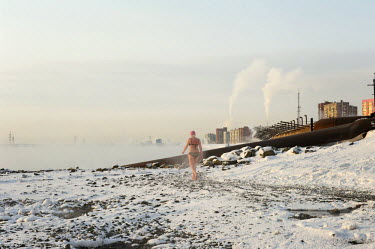 A woman walks through the snow in her bikini in Norilsk. A popular past time is to take a dip in holes cut into the ice and then retire to a 'banya' (or sauna) which is heated with steam from the near...