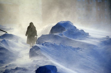 A woman walks down a street in Norilsk in a snowdrift. The city is covered in snow for around 8 to 9 months a year. Each year around 10 tonnes of snow fall on the city for each inhabitant.  The city i...