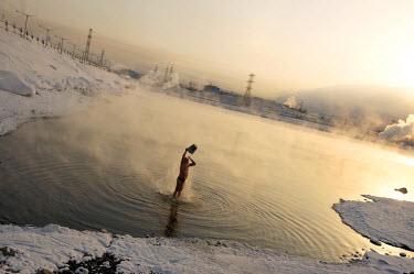 A man pours warm water over himself as part of a popular past times amongst Norilsk residents who enjoy a dip in an icy lake as part of the so-called 'Walrus' club. A popular past time is to take a di...