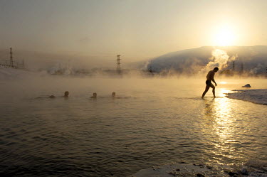 A man walks out of a pond of heated water in Norilsk. A popular past time is to take a dip in holes cut into the ice and then retire to a 'banya' (or sauna) which is heated with steam from the nearby...