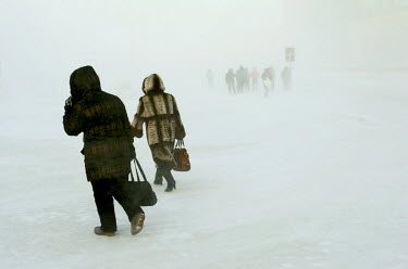 People walk through a snow storm in the city of Norilsk. The city is covered in snow for around 8 to 9 months a year. Each year around 10 tonnes of snow fall on the city for each inhabitant.  The city...