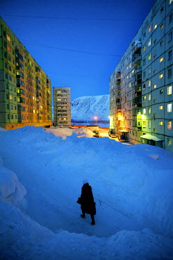 A woman walks through a tunnel that has been dug through snow which has piled in a residential area of Norilsk.  The city is covered in snow for around 8 to 9 months a year. Each year around 10 tonnes...