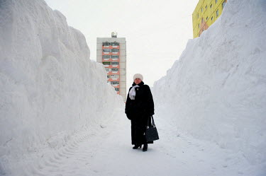 A woman stands in the middle of a tunnel dug through the snow in Norilsk. The city is covered in snow for around 8 to 9 months a year. Each year around 10 tonnes of snow fall on the city for each inha...