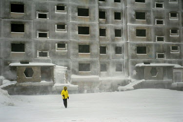 A woman walks in front of an abandoned multi storey residential building in Norilsk.  The city is facing an infrastructural crisis since most of the buildings were built on pylons driven into permafro...