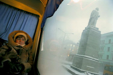 A woman rides on a public bus past a statue of Vladimir Lenin in Norilsk. The city is one of the coldest in the world with winter temperatures averaging -30C. Around 280 days of the year have freezing...