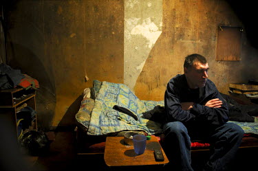 A man sits on his bed in a run down hostel in Norilsk. In order for citizens of former Soviet republics to come and live in the city they are required to get special permits which are issued when a co...