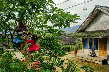 Children play outside their home near the village square. All the homes are largely made out of natural materials that can be found in the nearby forest. However over the years these homes have been m...