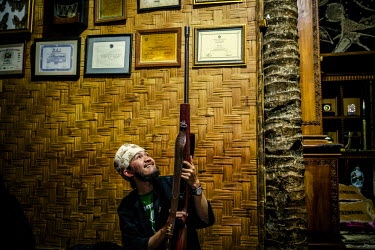 The village leader, Aba, is a fan of technology and also of guns. Here he is shown a long-range competition rifle by a regular visitor to the village from Jakarta. They spend the evening discussing gu...