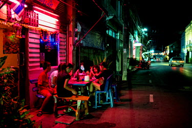 Sex workers wait for customers in a karaoke bar that also serves as a brothel and is frequented by fisherman.