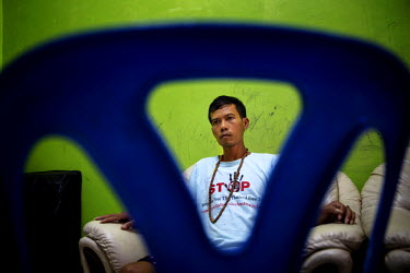 Lang Long, 30, from Kampong Cham, Cambodia watches TV in a safe house in Songkhla. He was rescued from a fishing boat where he was restrained with shackles and forced to work on and remain out at sea...