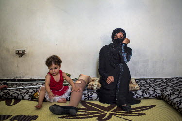 Awatef, 25, pictured with her daughter Sabah, two, in their home in Tripoli, Lebanon. Six months earlier, Awatef was giving her young children a bath outside her house in Homs (Syria) when she heard s...