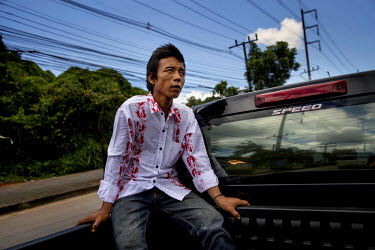 San Oo, 35, who was trafficked into Thailand from Myanmar and sold to a fishing boat on which he was forced to work at sea for two years and six months sits in the back of a pick-up truck. During his...