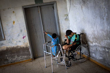 Hussein, 10, pictured with his new prosthetic limbs at his family's accommodation in a collective shelter in Tripoli, Lebanon. Hussein was playing with his siblings and cousins in the living room of h...