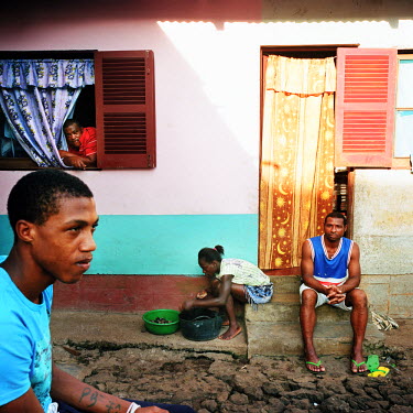 A family sitting outside in the afternoon. The rooms where they live are extensions of the 'Senzala' (worker's quarters built by the Portuguese during the colonial rule).