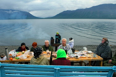 A group of Norilsk residents sit at a table on the shore of Lama Lake near Norilsk on an outing from the city. When the weather becomes slightly warmer residents are keen to get outside, having spent...