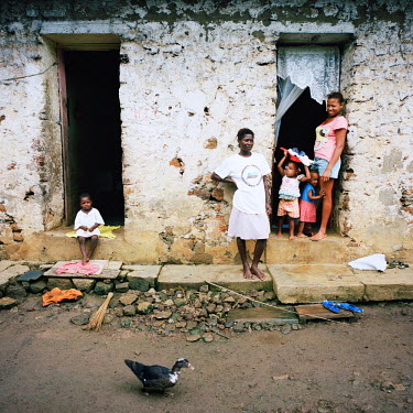 Women and children next to the entrance of a 'senzala', the former worker's quarters on one of the island's many large colonial era plantations. Once home to slaves and indentured workers, they still...