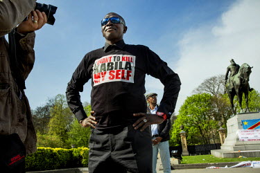 A protestor against the regime of Laurant Kabila in Democratic Republic of Congo is photographed by media near the European parliament during an EU-Africa trade summit.