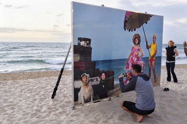 People enjoying Annette Thas' 'Dame Cockatoo and Entourage' at 'Sculptures by the Sea' on Cottesloe Beach.
