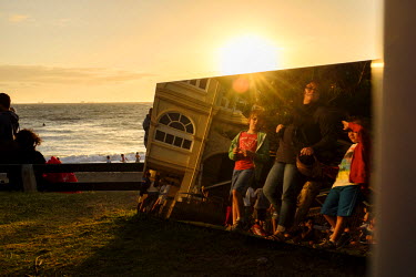 A family walks past an artwork at 'Sculptures by the Sea' on Cottesloe Beach.