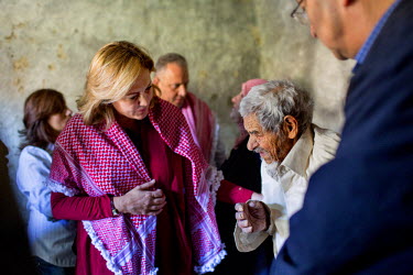 Princess Alia bint Hussein of Jordan visits the home of a family living in poverty in order to distribute aid vouchers.