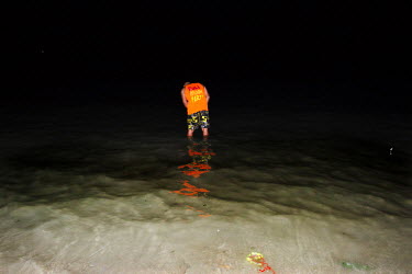 A young man urinates in the ocean at midnight. The full moon party on Haad Rin Beach on the island of Ko Pha Ngan in Thailand attracts about 30 000 partying backpackers and other tourists every synodi...