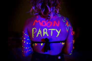 'FULL MOON PARTY' written in neon letters on the back of reveller Eloise (23). The full moon party on Haad Rin Beach on the island of Ko Pha Ngan in Thailand attracts about 30 000 partying backpackers...