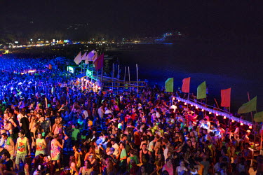 People dance on the crowded beach. The full moon party on Haad Rin Beach on the island of Ko Pha Ngan in Thailand attracts about 30 000 partying backpackers and other tourists every synodic month.